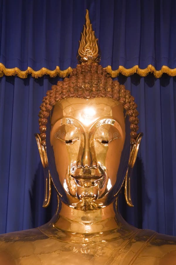 Close up of the face of the giant solid gold Buddha at Wat Trai Mit in Bangkok, Thailand. Largest (5-1/2 tons) solid gold Buddha in the world. Close up of the face of the giant solid gold Buddha at Wat Trai Mit in Bangkok, Thailand. Largest (5-1/2 tons) solid gold Buddha in the world.