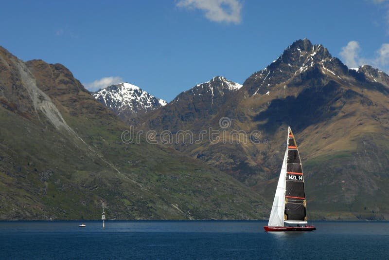 Boat sailing on wakatipu lake, in front of snowy mountain near Queenstown, New Zealand. Boat sailing on wakatipu lake, in front of snowy mountain near Queenstown, New Zealand