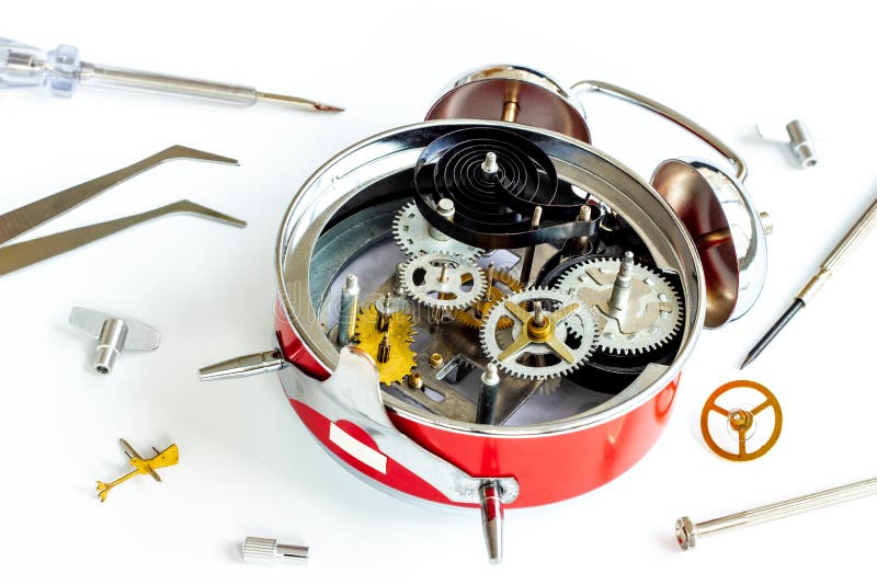 Watch Mechanism and Watchmaker Tools Near Open Alarm Clock Stock Photo