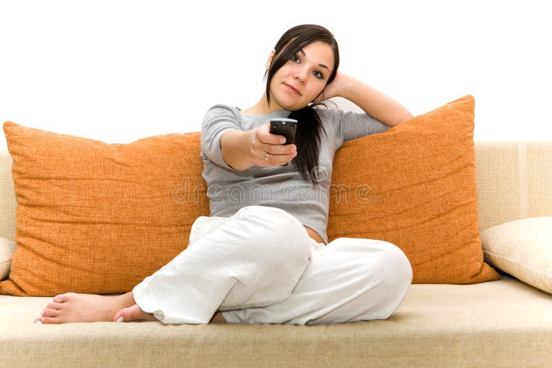 Attraente donna bruna sul divano a guardare la tv.