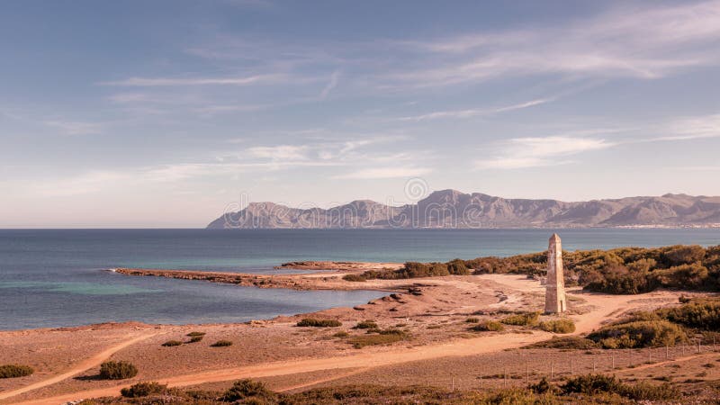 Watchtower Santa Margalida with sea and blue skies, mountains in the distance, located between Can Picafort and Son Serra De