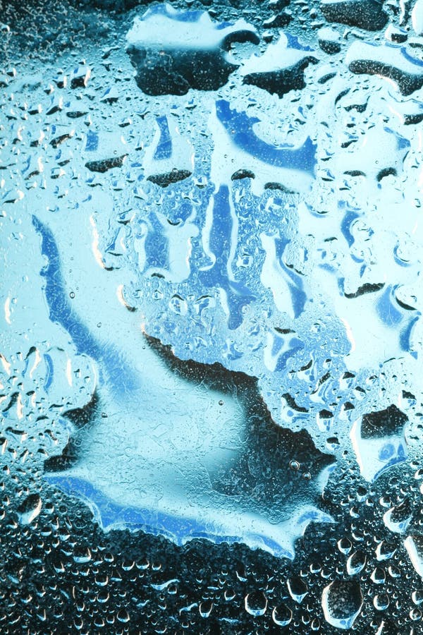 A beautiful image of water drops on a blue glass background. A beautiful image of water drops on a blue glass background.