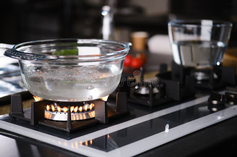 Water boiling in borosilicate glass casserole on gas stove