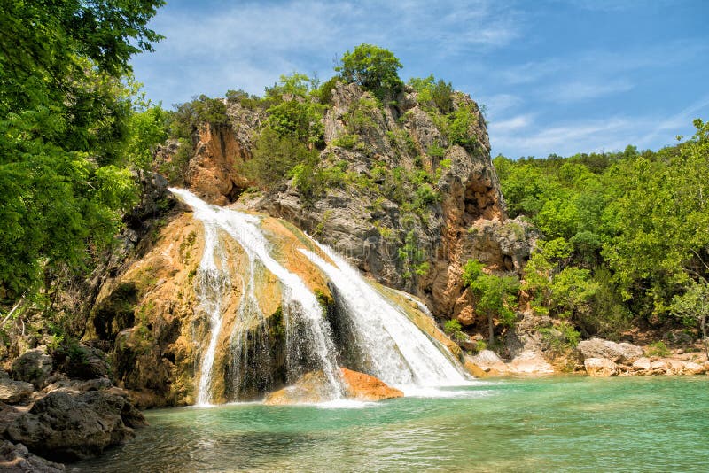 Water cascading over rocks into a natural pool at Turner Falls