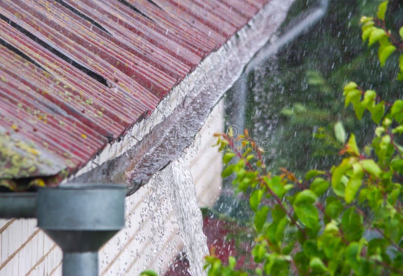 Water overflowing from damaged rain gutter during a heavy rainstorm. Water overflowing from damaged rain gutter during a heavy rainstorm