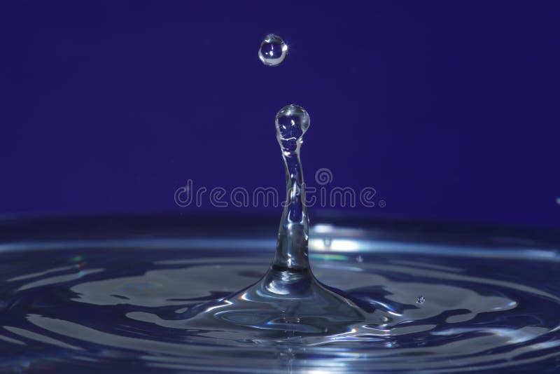 Genuine water drop impact with tower of water and droplet