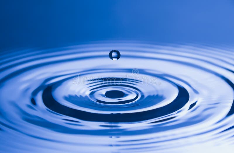 Close-up of water droplet reflected on blue background