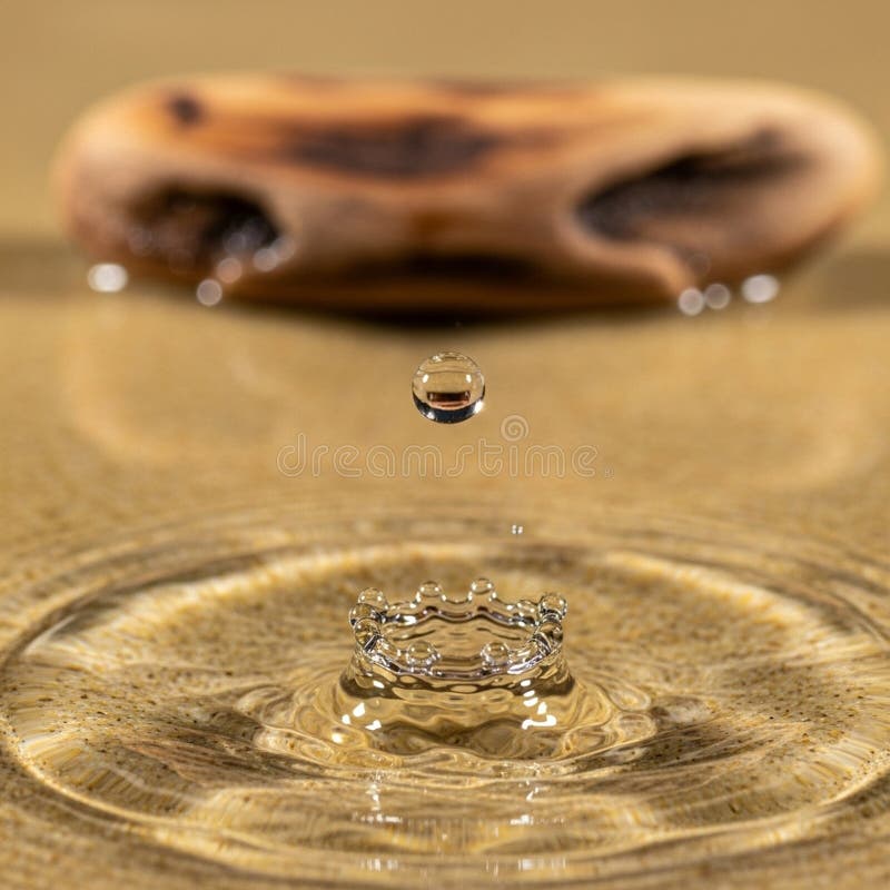 Water droplet suspended above a reflective water surface creating a crown-like splash below. The vector illustration