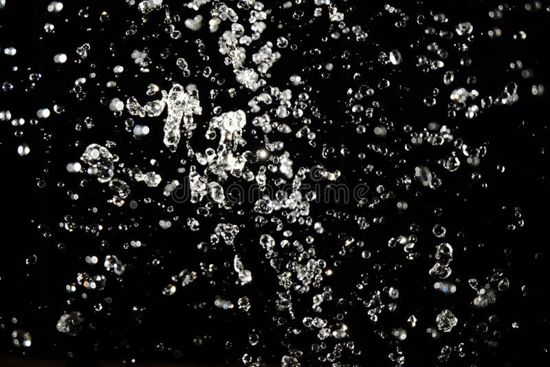 Water drops on black background flying in the air. Lewitation