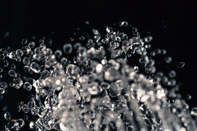 Water drops levitation on black background and do it against law of physics