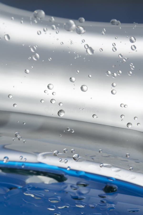 Water drops on a silver metallic surface with blue background