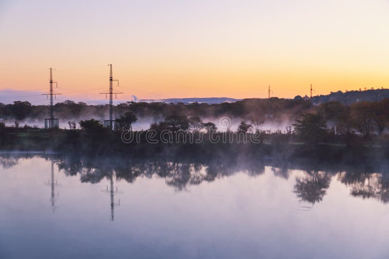 Water Evaporation on the River at Dawn and Lonely Fisher on a Boat