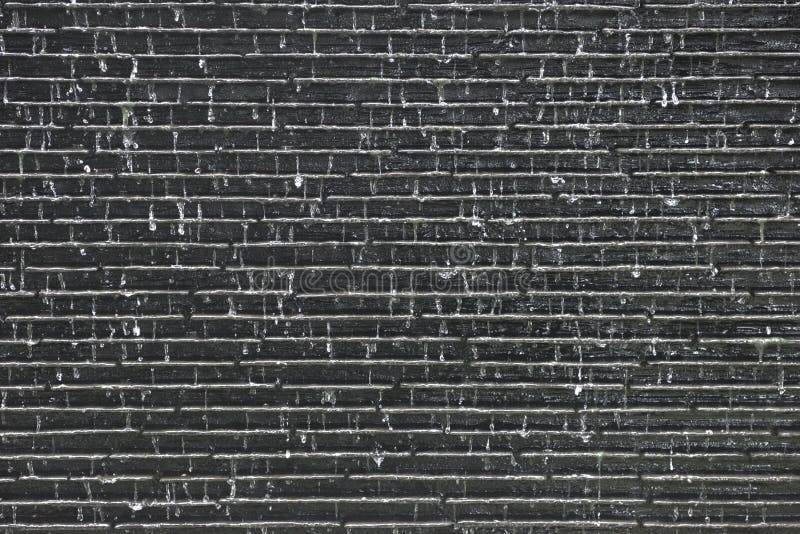 Water fall on old brick grey wall background