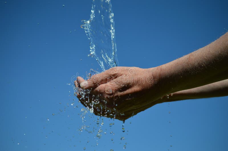 Water flowing from the sky into open hands