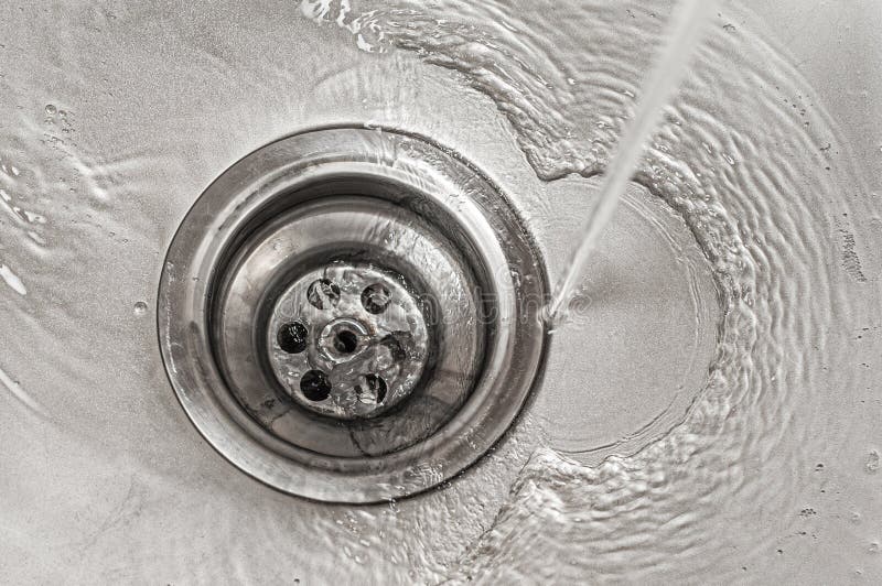 Water Flows into the Stainless Steel Kitchen Sink Drain Stock Image