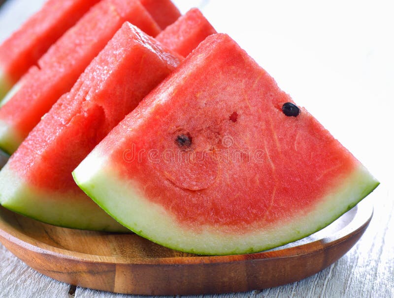 Water melon in wood plate on table stock images Water melon in wood plate on table stock images