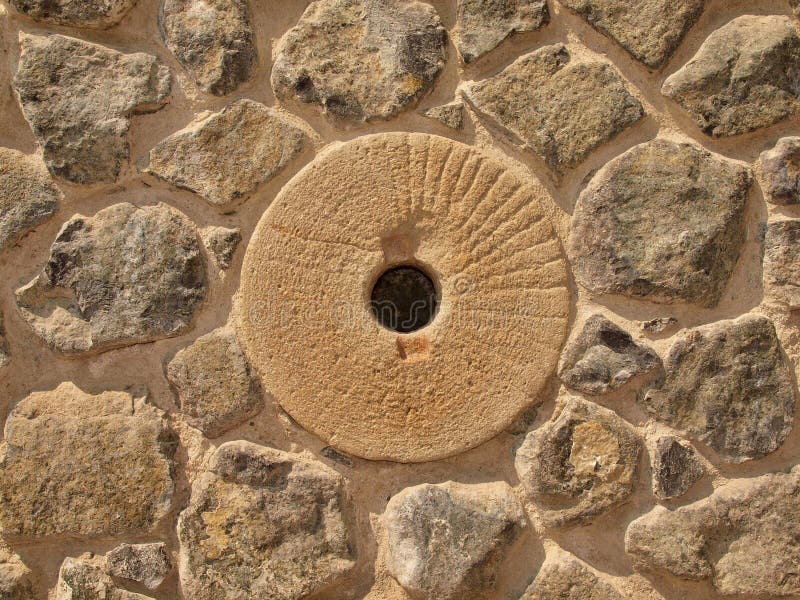 Water mill stone in stony wall from nature material, broken marl stone , traditional building materials.