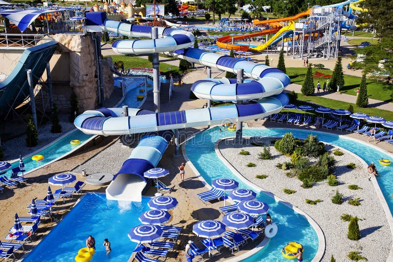 Water Park on the beach on a Sunny morning. Rides in the form of spiral pipes. There are channels with running water at the bottom. Striped blue umbrellas royalty free stock photography Water Park on the beach on a Sunny morning. Rides in the form of spiral pipes. There are channels with running water at the bottom. Striped blue umbrellas royalty free stock photography