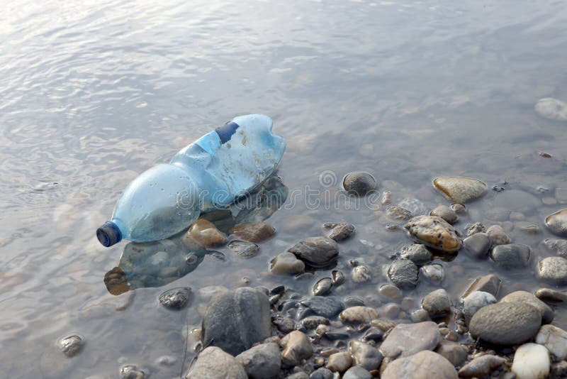 Water Pollution. Plastic Bottle on the River Beach. Stock Photo Image