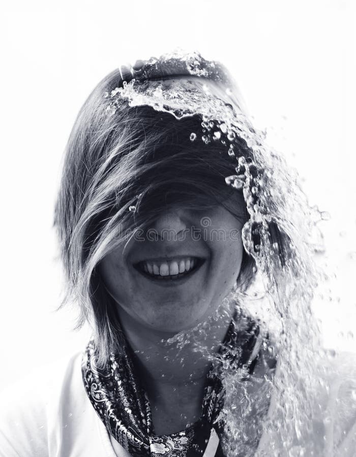 Water poured over laughing womans head in surprise