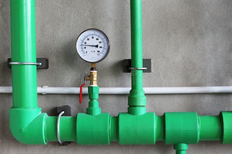 Water Pressure Gauge with Valve in Pipe on Concrete Wall Background