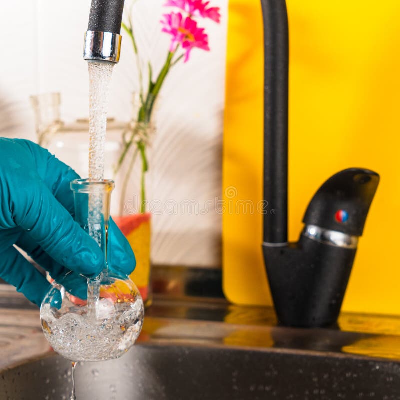 Water Purification Specialist Tap Water Pours into a Glass Flask Stock