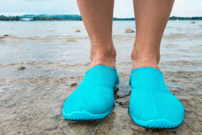 Water Shoes / Blue Swimming Shoes on Rocks in Water on Beach. Closeup ...