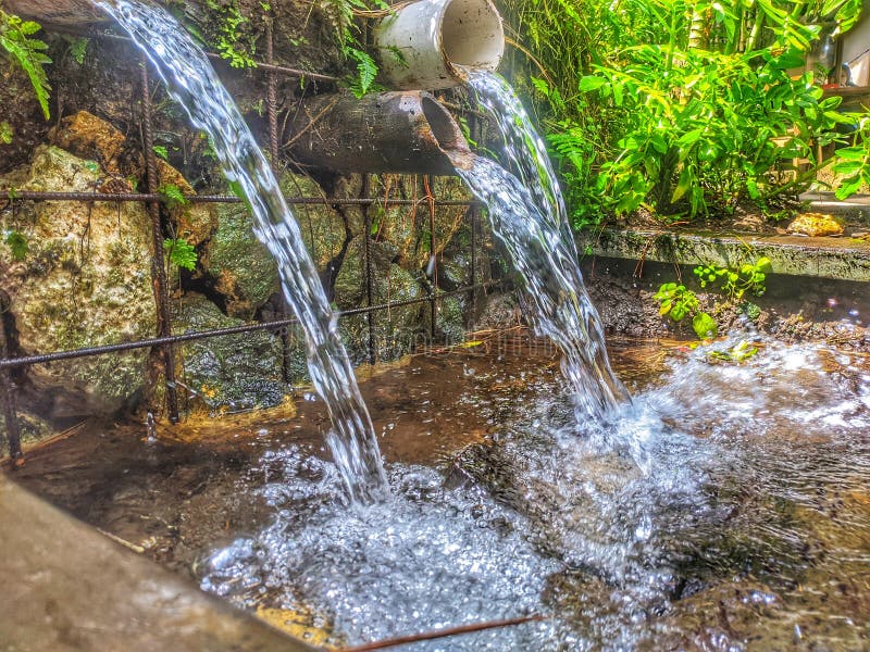 The Water Source from the Hill Flows through the Pipe Stock Photo