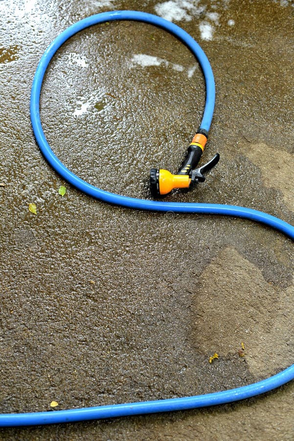 Water Spay Gun and Pipe on Wet Ground, Washing Tool Stock Photo Image