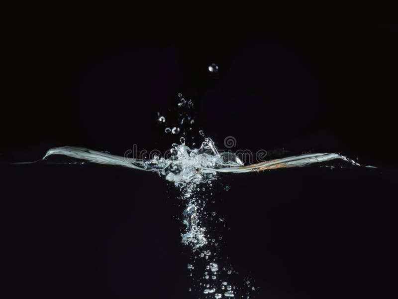 Water splash, rippling surface and small water bubbles isolated on black background, close up view. Perfect for royalty free stock photography Water splash, rippling surface and small water bubbles isolated on black background, close up view. Perfect for royalty free stock photography