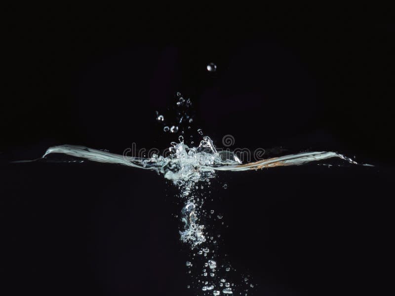 Water splash, rippling surface and small water bubbles isolated on black ba...