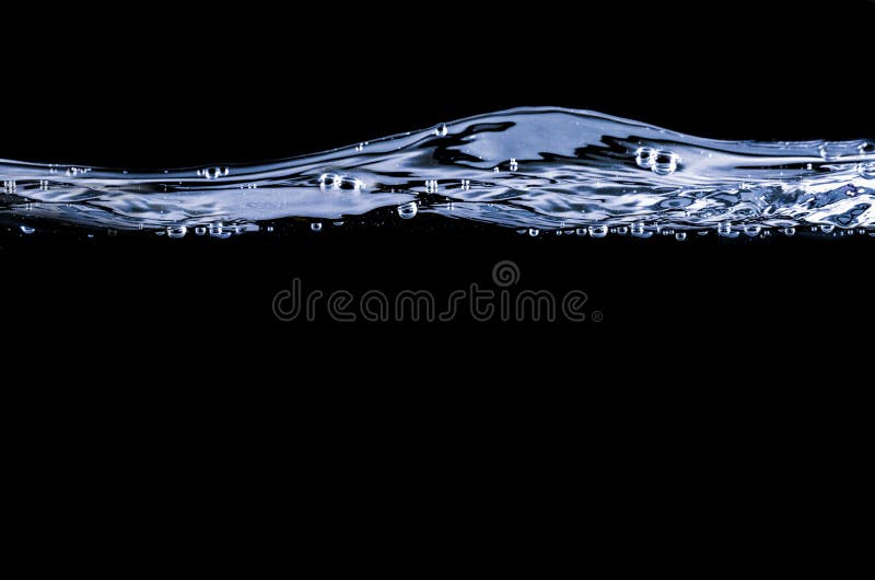 Water surface with small waves and bubbles ; isolated on black background