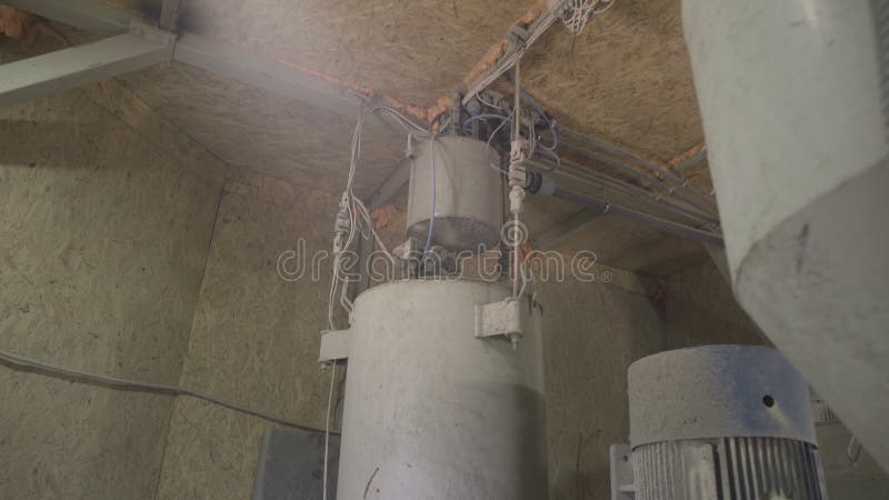 Water tanks on concrete mixing unit at factory. Camera moves up and down along industrial equipment at cement production