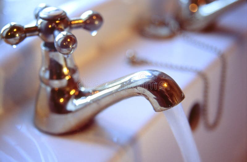 Water Tap. A bathroom tap with running water Water Tap. A bathroom tap with running water