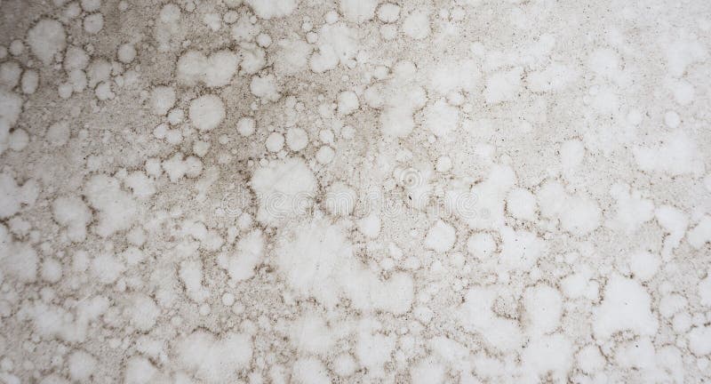 An image of waterdrop stains on a white dusty table. An image of waterdrop stains on a white dusty table