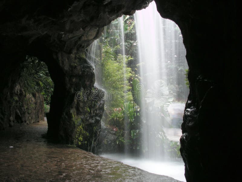 Man-made waterfall with a small walkway behind it. Man made waterfall stock images, royalty-free photos and pictures