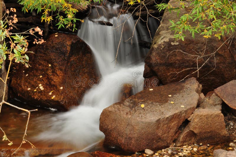 Waterfall cascading down rocks in Rocky Mountains royalty free stock photo