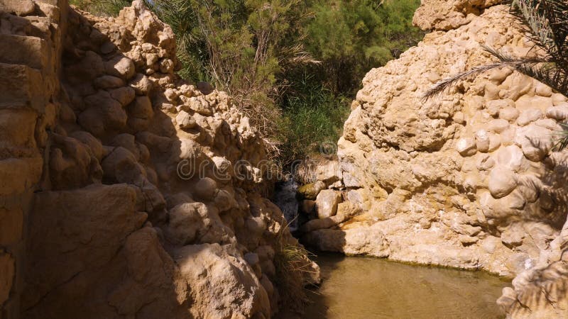 Waterfall flowing on rocks in Oasis Chebika at Sahara desert, Tunisia