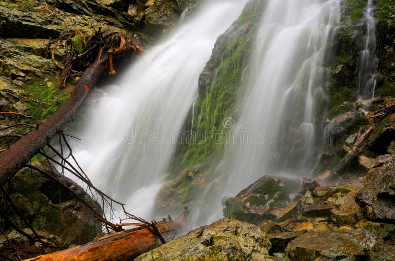 Waterfall among green wet stones