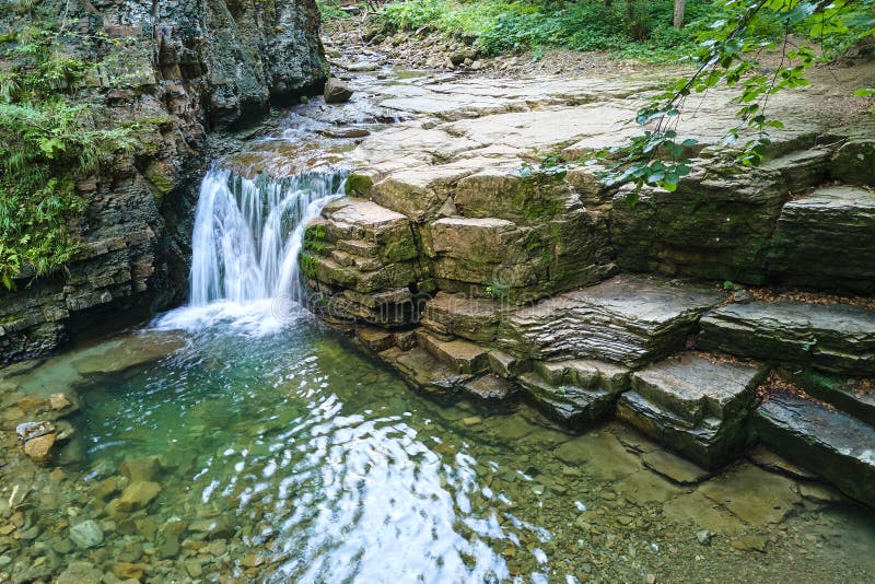 Waterfall on Mountain River with White Foamy Water Falling Down from