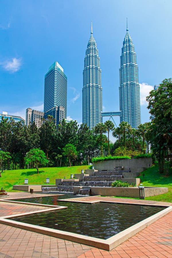 Petronas Towers surrounded by tropical and rain forest. Waterfall of Petronas Towers, Twin Towers surrounder by the man-made tropical forest in the Kuala Lumpur Petronas Towers surrounded by tropical and rain forest. Waterfall of Petronas Towers, Twin Towers surrounder by the man-made tropical forest in the Kuala Lumpur