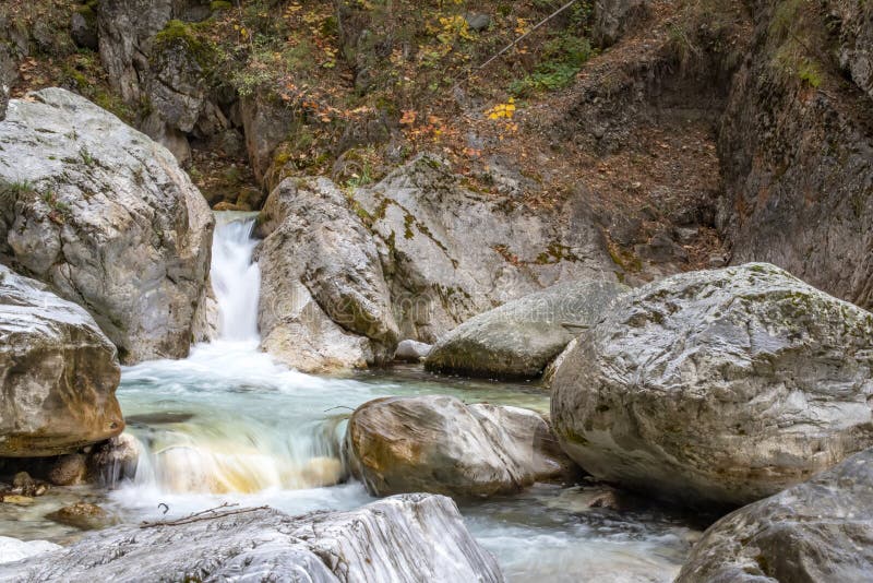 Waterfall and river between stone boulders in a mountain autumn forest royalty free stock photos Waterfall and river between stone boulders in a mountain autumn forest royalty free stock photos