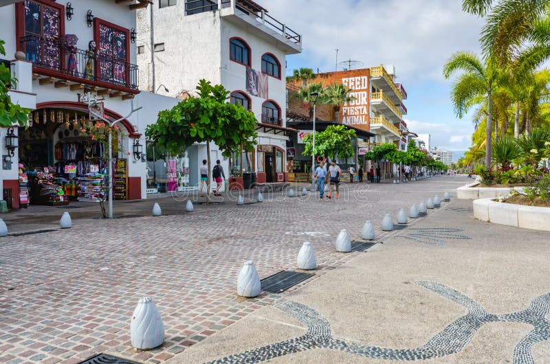 Tourists walking past stores along the Malecón, a 12-block, mile-long esplanade in Puerto Vallarta, Jalisco, Mexico. Tourists walking past stores along the Malecón, a 12-block, mile-long esplanade in Puerto Vallarta, Jalisco, Mexico.