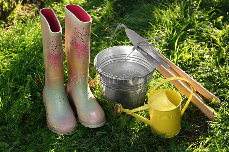 Watering Can, Gardening Tools and Rubber Boots on Green Grass Outdoors