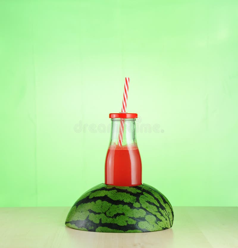 Watermelon juice in glass bottle inside half a watermelon royalty free stock image