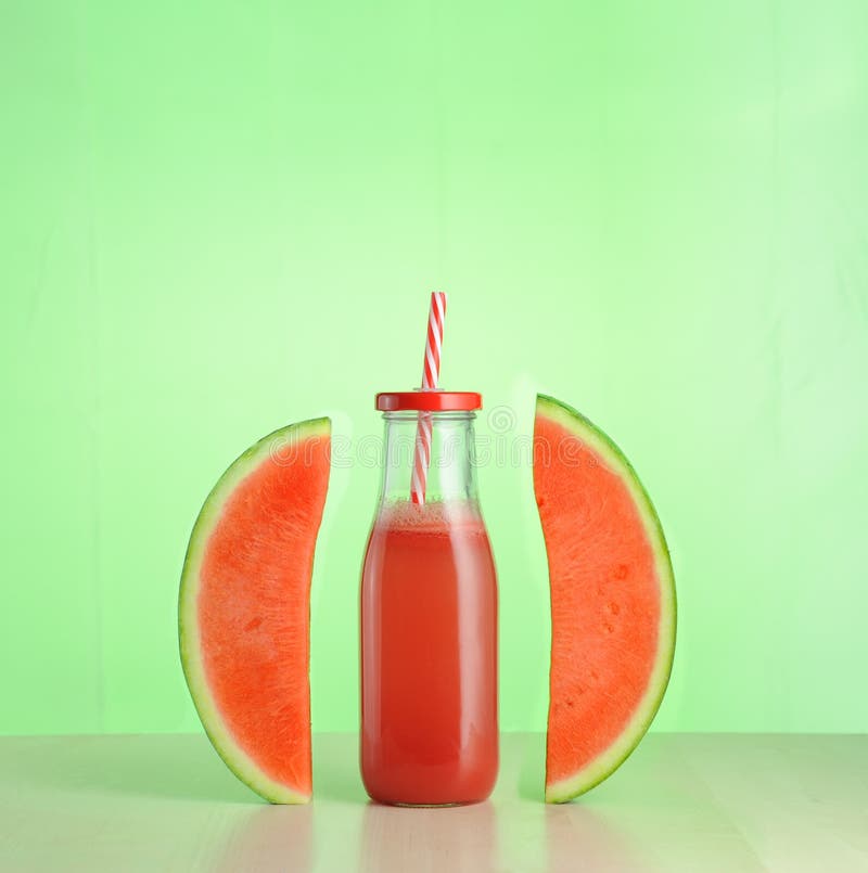 Watermelon juice in glass bottle between two slices of watermelon royalty free stock photos