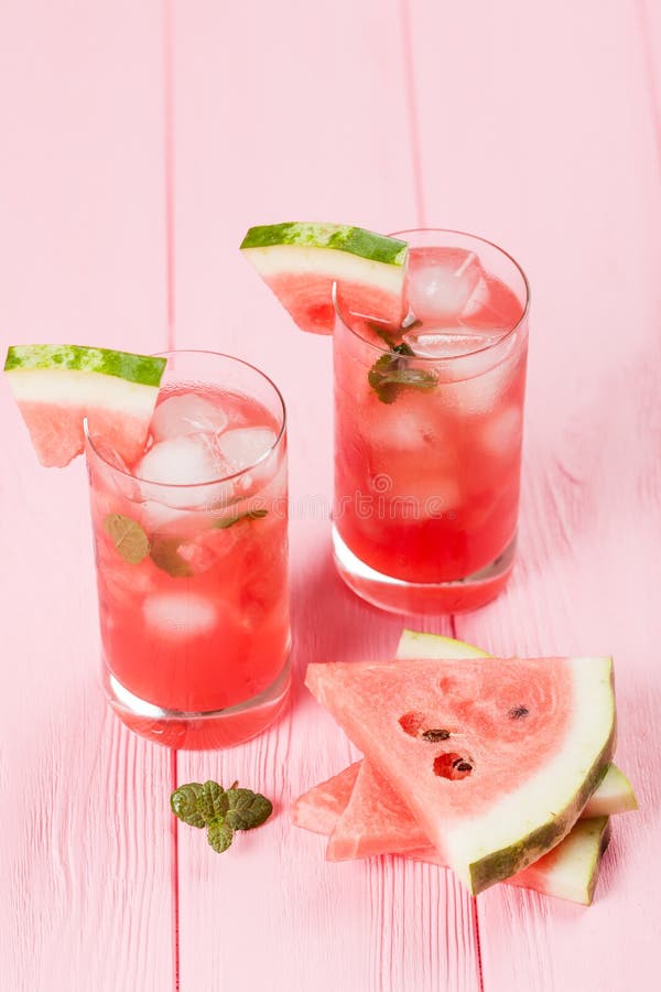 Watermelon lemonade with ice and mint leaves. Homemade lemonade of ripe berry with red and green ripes. Glass of cold watermelon t