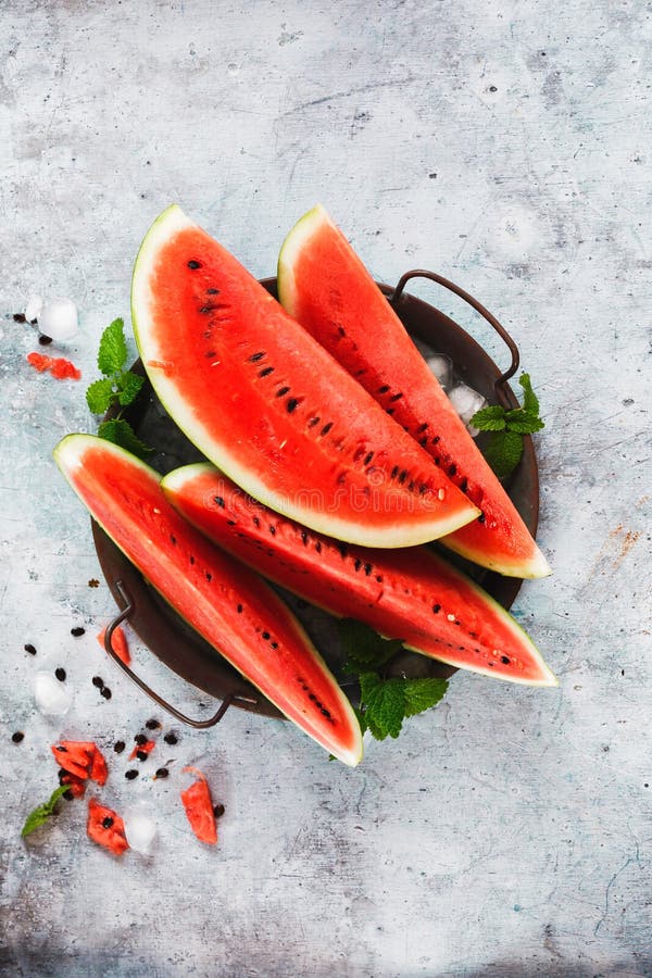 Watermelon slices with ice cubes on metal tray