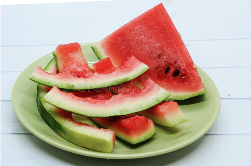 Close-up of triangular piece watermelon and watermelon rind on on a light green flat plate. Ripe juicy watermelon, organic farm products, seasonal food, eaten food. Triangular cut watermelon stock images, royalty-free photos and pictures