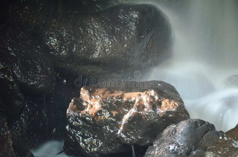 Waterval in hol achter rots in bos royalty-vrije stock foto Waterval in hol achter rots in bos royalty-vrije stock foto